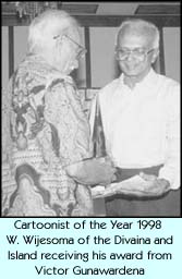 Cartoonist of the Year 1998 W. Wijesoma of the Divaina and Island receiving his award from Victor Gunawardena